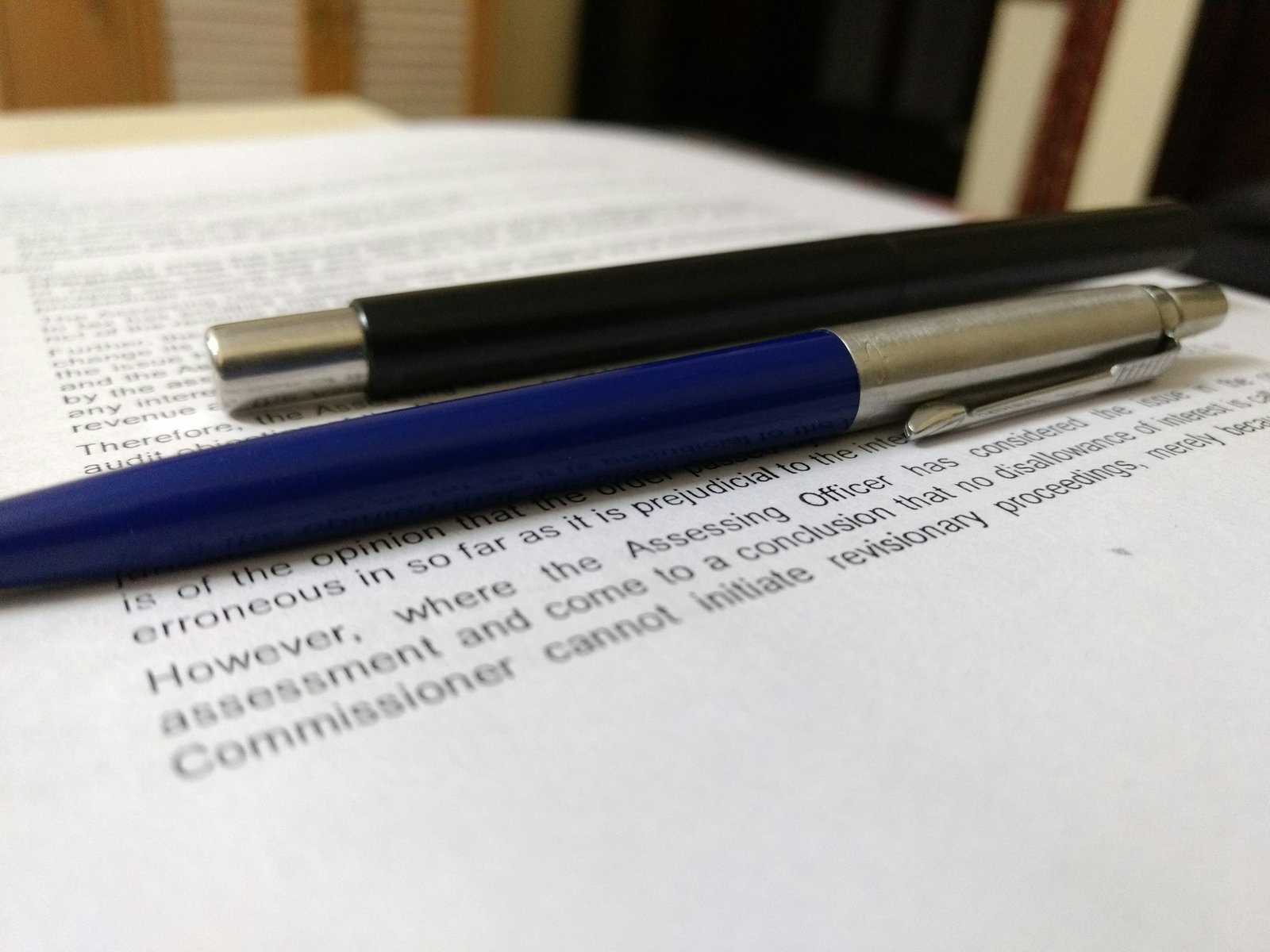 Two pens resting on the open page of a legal document